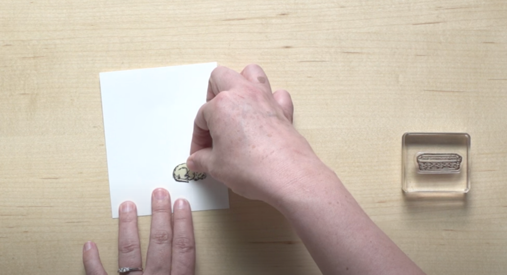 Place your newly created stamp mask over the stamp on the piece of paper that you started with.