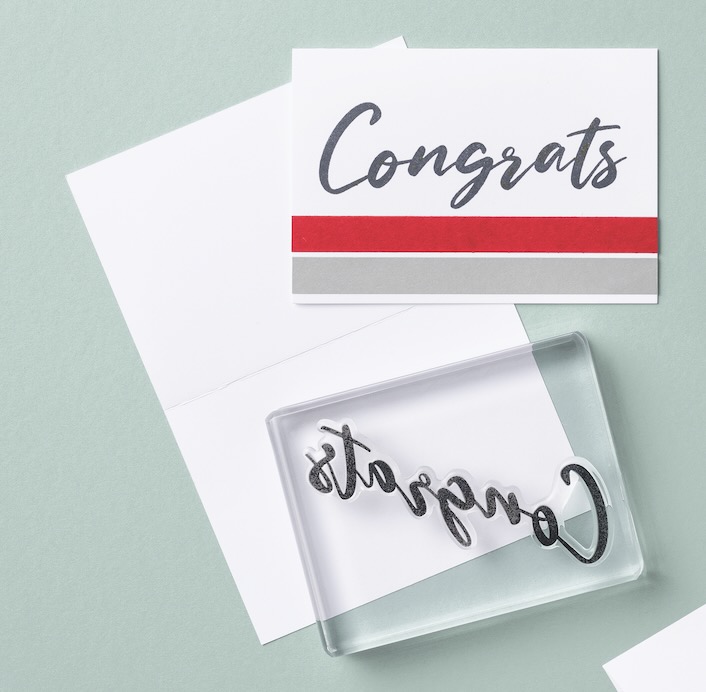 Homemade Congratulations card and clear stamp against a blue background