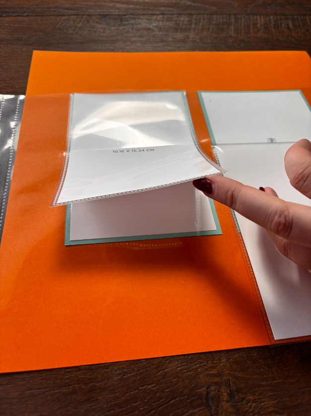 Schuif je Flip Flap door de opening die je net in de bovenste laag van je page protector hebt geknipt zodat de Flip Flap aan de buitenkant van de page protector zit.