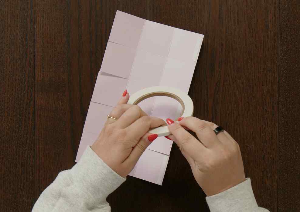Applying strong adhesive to the cardstock flaps before assembling a handmade paper gift box.