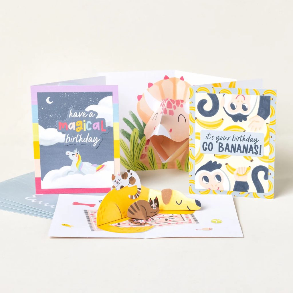 Collection of colorful pop-up birthday cards from the Pop-Up Pals Kit featuring a unicorn, monkey, dinosaur, and sleeping dog with playful birthday greetings.