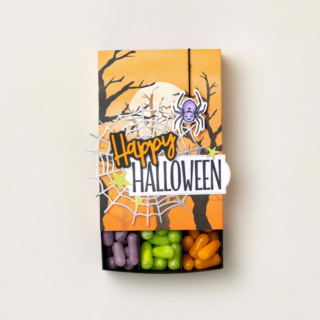 Boîte à bonbons d'Halloween faite main, ornée d'une araignée et de motifs de toile d'araignée, dotée d'un tiroir coulissant rempli de bonbons d'Halloween colorés.