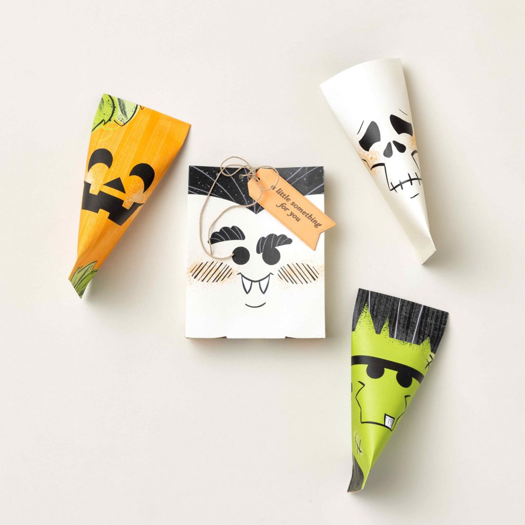 Cornets et porte-bonbons d'Halloween faits main, réalisés à partir de papier à motifs d'Halloween, destinés aux petits cadeaux de fête et aux friandises distribuées lors de la tournée « des bonbons ou un sort ».