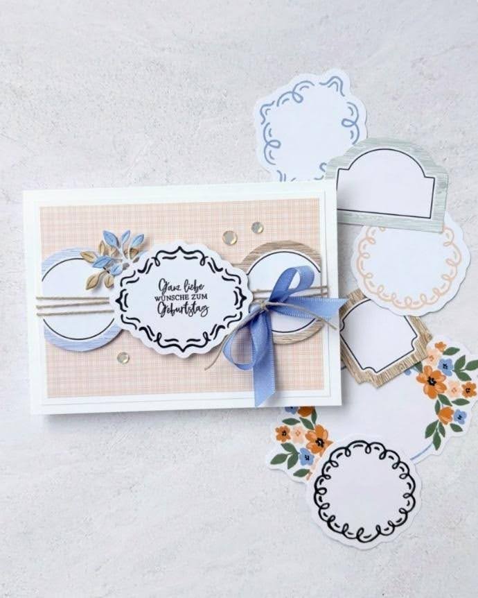 Handmade birthday card with decorative frames, blue ribbon, floral accents, and layered labels