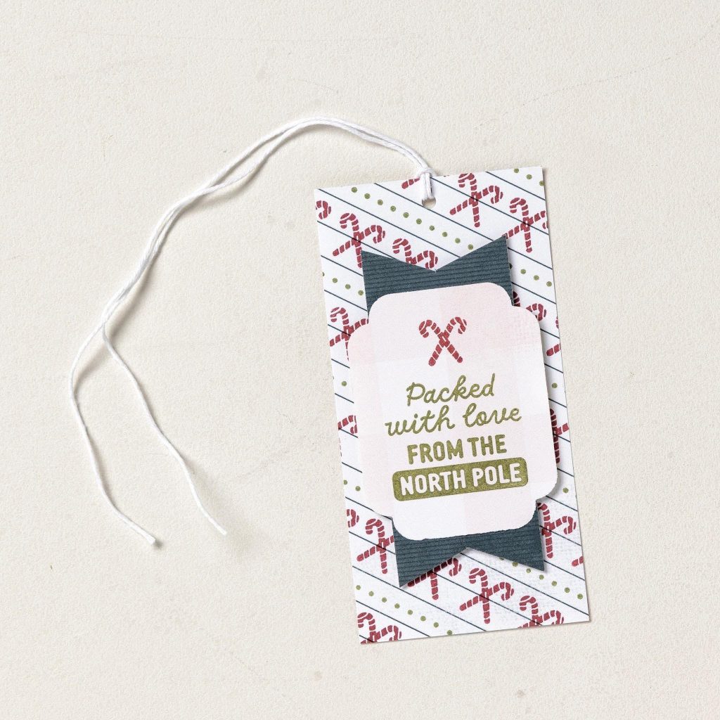 Candy cane gift tag with a dark banner, white string, and the message “Packed with love from the North Pole.”