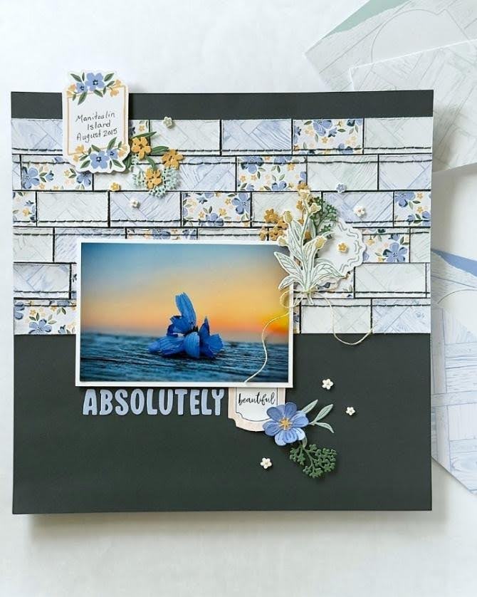 DIY Card with patterned paper strips, blue floral embellishments, and an ocean photograph