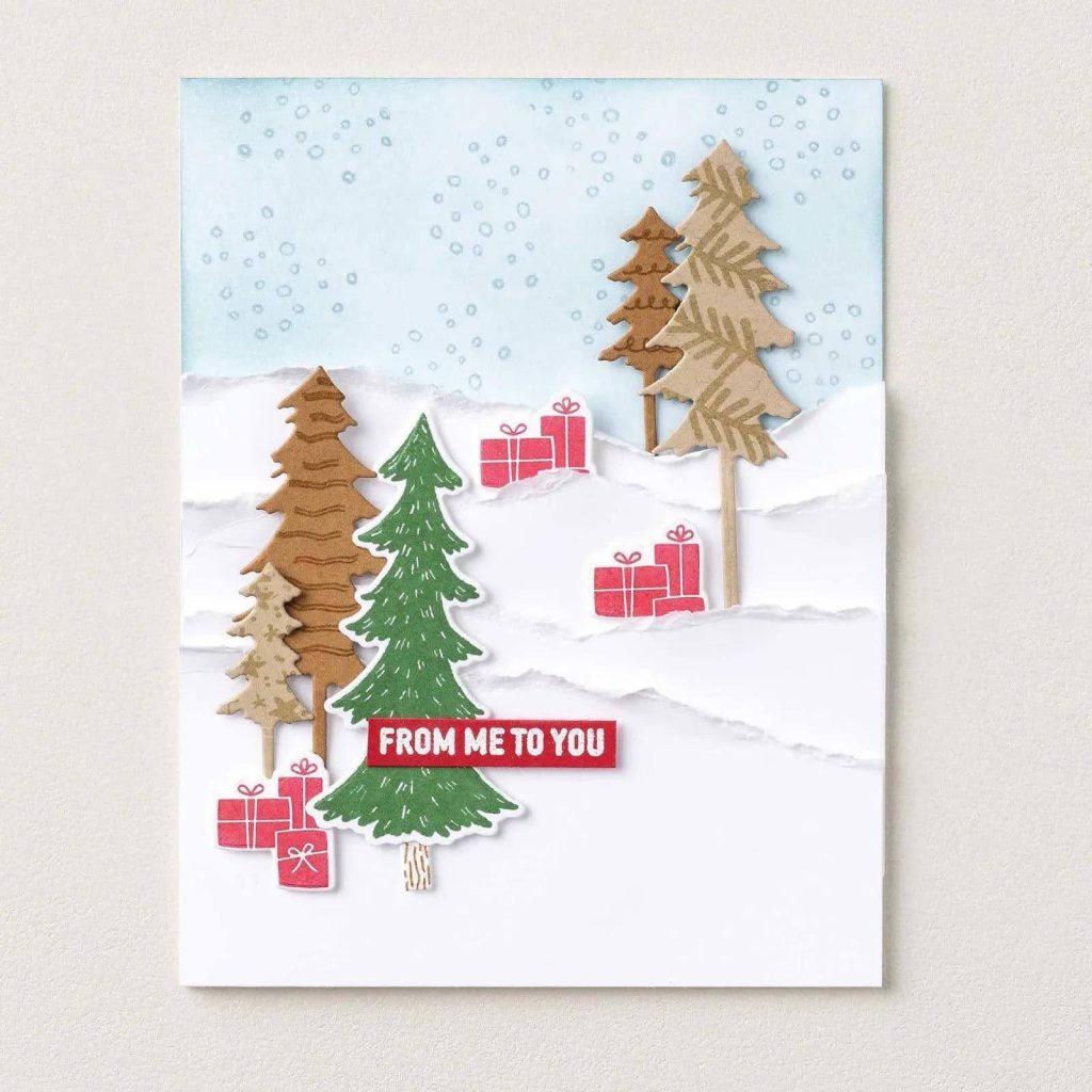 Kerstkaart met groene en bruine papieren bomen, rode cadeautjes, gescheurde witte sneeuwbanken en de tekst ‘From Me to You’.