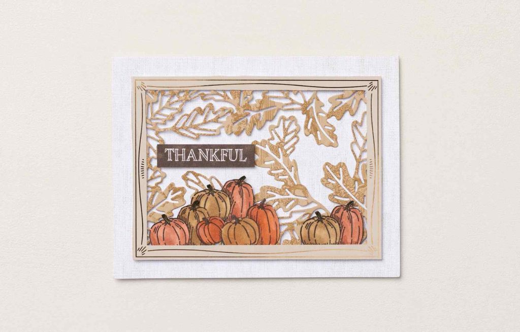 Handgemaakte herfstkaart met een dankbaar thema, met in lagen geplaatste pompoenen en gestanste herfstbladeren