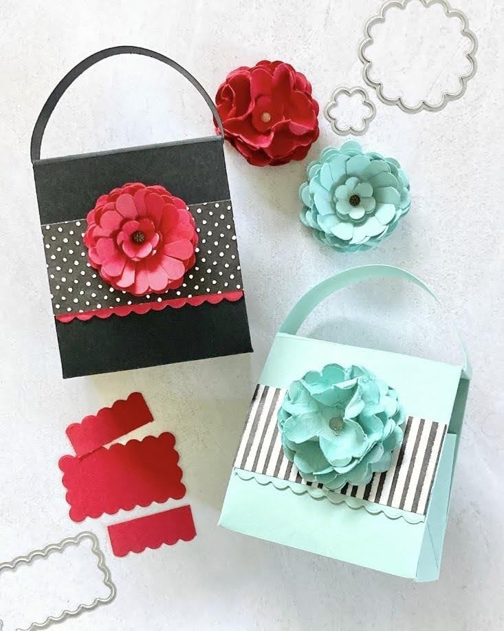 Black and light blue handmade paper gift bags decorated with layered pink and blue cardstock flowers and patterned paper