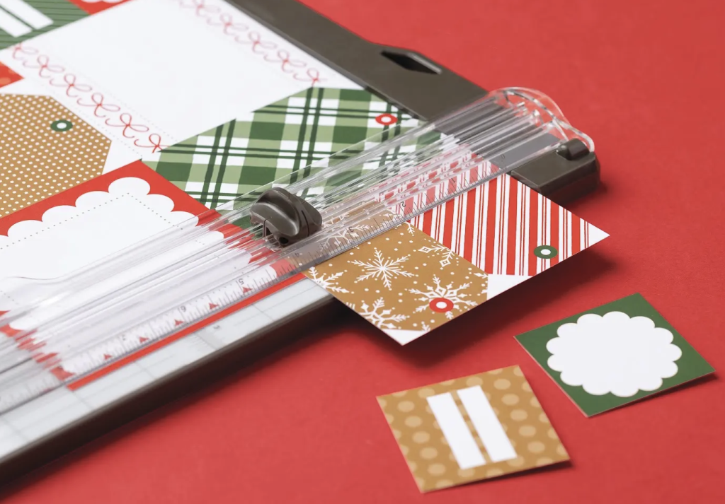 Une découpeuse de papier permet de découper du papier à motifs festifs : à carreaux, à rayures et à flocons de neige, destiné à la confection de cartes de Noël faites main.