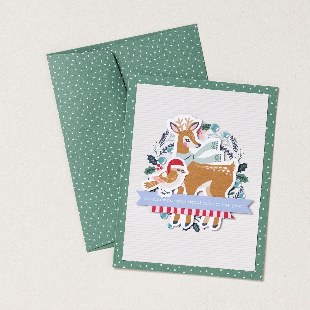 Carte de Noël et enveloppe assortie à pois verts, représentant un renne portant une écharpe, un oiseau coiffé d'un bonnet de Père Noël et une banderole de Noël.